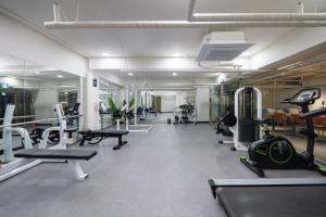 a gym with treadmills and machines in a room at Kenny Stay Busan Gijang in Busan