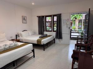 a hotel room with two beds and a balcony at Pagi Pagi villas in Ao Nang Beach