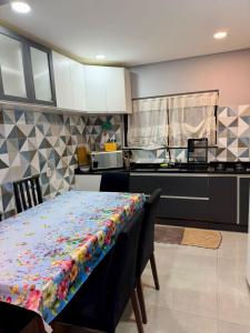a kitchen with a table with a colorful blanket on it at Casa ao lado do parque Beto carreiro da de ir a pé para o parque João carlos casas in Penha