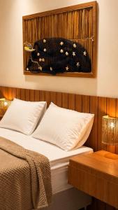 a bed in a room with a picture on the wall at Estúdio Premium em Japaratinga - Unidade Coralli - Vila Naluri in Japaratinga +7 photos