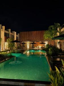 a swimming pool in a building at night at Estúdio Premium em Japaratinga - Unidade Coralli - Vila Naluri in Japaratinga