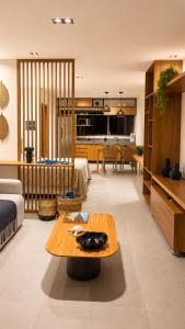 a living room with a table and a kitchen at Estúdio Premium em Japaratinga - Unidade Coralli - Vila Naluri in Japaratinga