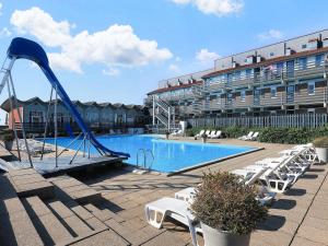 a pool with a slide in front of a hotel at Home in Faaborg with sauna in Faaborg