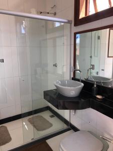 a bathroom with a sink and a toilet and a mirror at Cantinho do Rosário in Diamantina