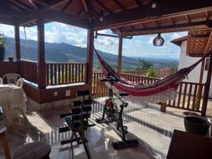 a hammock on a balcony with a view of the mountains at Cantinho do Rosário in Diamantina