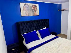 a blue bedroom with a bed with blue walls at Hôtel Famigni in Douala