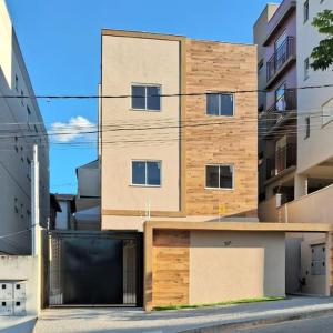 a building with a garage in front of it at Apartamento em Poços - Varanda com Churrasqueira in Poços de Caldas