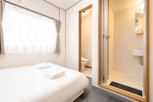 a bedroom with a bed and a glass shower at Namba 5min by subway OYASUMI Manga HOTEL 24 hours Self-check-in Japanese-Style hotel in Osaka +69 photos
