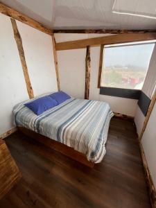 a bed in a small room with a window at nido de mar in Cobquecura