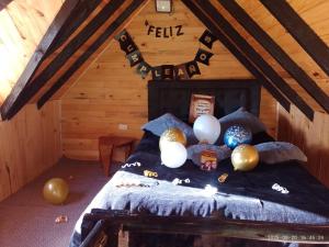 a room with balloons on a bed in a attic at Cabañas Del Árbol n2 in Tres Esquinas