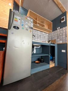 a refrigerator in a kitchen with blue walls at nido de mar in Cobquecura