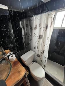 a black and white bathroom with a toilet and a table at nido de mar in Cobquecura