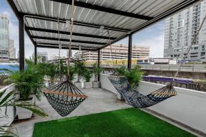 a rooftop patio with two hammocks and plants at The Quarter Bangkok Ratchathewi in Bangkok