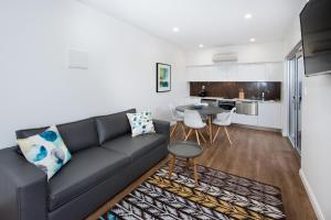 a living room with a black couch and a table at Loxton Courthouse Apartments in Loxton