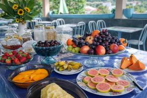 a blue table topped with plates of fruit and vegetables at Pousada das Estrelas - Centro de Conservatória - rua principal in Conservatória