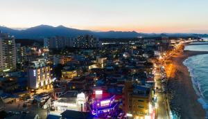 eine nachts erleuchtete Stadt mit dem Strand in der Unterkunft Cocomo Spa in Sokcho + 6 Fotos