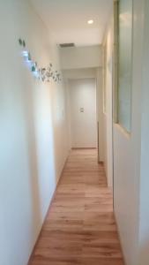 a hallway with white walls and a wooden floor at Depto en Edificio Céntrico in Trelew