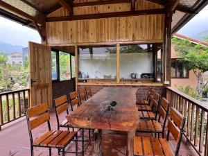 a large wooden table and chairs on a balcony at Zay Riverside House in Tả Van +46 photos