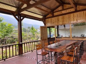 a dining room with a large wooden table and chairs at Zay Riverside House in Tả Van