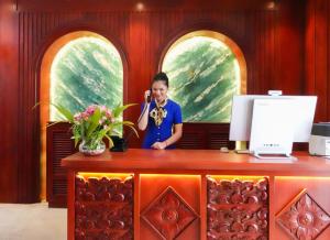 a woman talking on a cell phone at a desk at Happy Resort Siem Reap in Phumi Ta Phul +40 photos