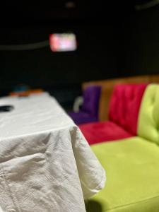 a table with a white table cloth and colorful chairs at Hôtel Famigni in Douala