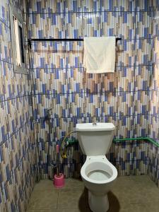 a bathroom with a toilet and a shower curtain at Hôtel Famigni in Douala +50 photos