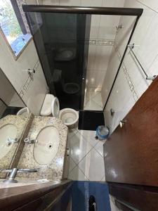 a bathroom with a toilet and a sink and a shower at apartamento aconchego 01 in Divinópolis