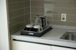 a kitchen counter with a coffee maker and cups at Gangneung Top Ocean in Gangneung +53 photos