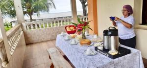 a woman taking a picture of a table with food at Casarão da ilha in Ilha Cotejuba