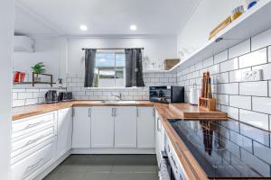 a kitchen with white walls and wooden counter tops at Hillcrest Harmony in Airlie Beach