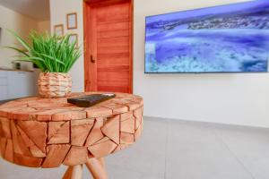 a wooden stool with a remote on it with a plant on it at Dlo Lanmou in Ducos
