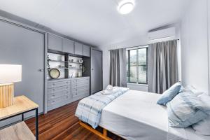 a bedroom with a large white bed and a desk at Hillcrest Harmony in Airlie Beach