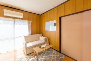 a living room with a couch and a table at もくハウス in Kamifukuoka +12 photos