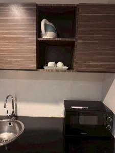 a kitchen with a sink and a microwave at H2 Hotel in Bangkok