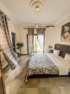 a bedroom with a zebra print bed with a window at CATU Colors and Comfort, A Choice of Studios in Dakar in Dakar