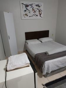 a bedroom with two beds and a table with towels at Pousada Paradise in Rio Grande
