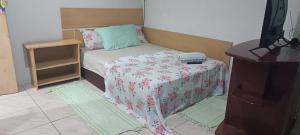 a room with a bed and a table with a phone on it at Pousada Paradise in Rio Grande