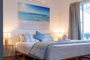 a bedroom with a bed with a picture of the ocean at Hillcrest Harmony in Airlie Beach +12 photos