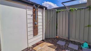 a backyard with a privacy fence and a garage at Beachside Cottage at Blacksmiths in Blacksmiths