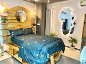 a bedroom with a blue bed and a mirror at Cozy Studio Apartment in Accra in Accra