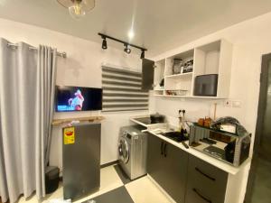 a kitchen with a washing machine and a tv at Cozy Studio Apartment in Accra in Accra +28 photos