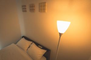 a lamp sitting next to a couch in a room at Grace Shintoshin in Saitama