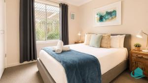 a bedroom with a large bed and a window at Beachside Cottage at Blacksmiths in Blacksmiths