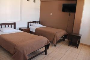 a hotel room with two beds and a flat screen tv at hotel turistico in Huaraz