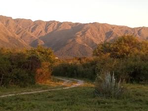 a dirt road through a field with mountains in the background at Mostepa in Carpintería +7 photos