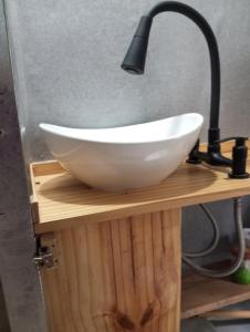 a white bowl sink on a wooden stand with a lamp at Mostepa in Carpintería