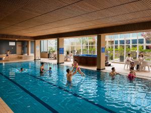 a group of people in a swimming pool at Rydges Canberra in Canberra