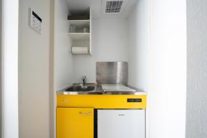 a kitchen with a yellow sink and a counter at Grace Shintoshin in Saitama +31 photos