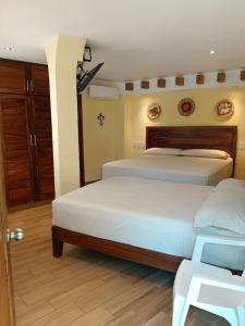 a bedroom with two beds and a wooden floor at hotel rio mar in Puerto Vallarta