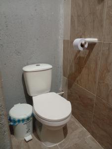 a bathroom with a toilet and a roll of toilet paper at Casa Hotel el Sueño in Villavieja +5 photos